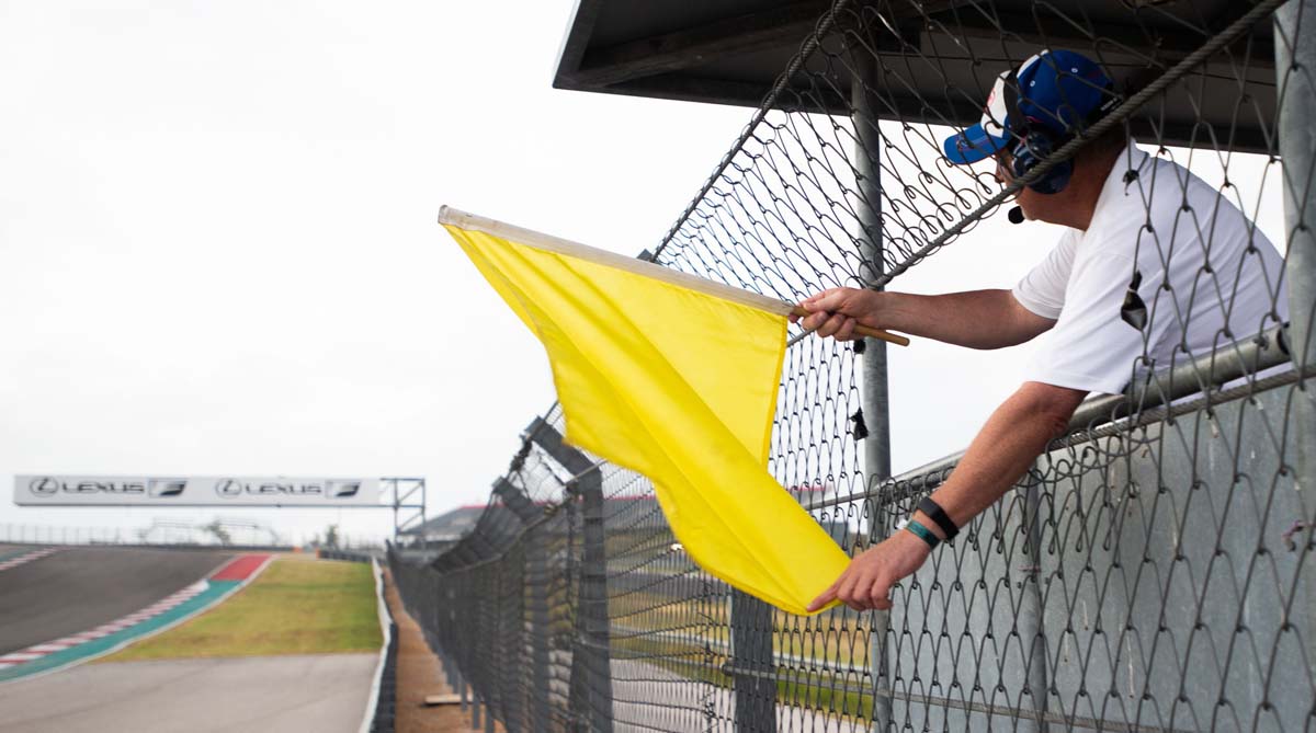 SCCA marshal with yellow flag